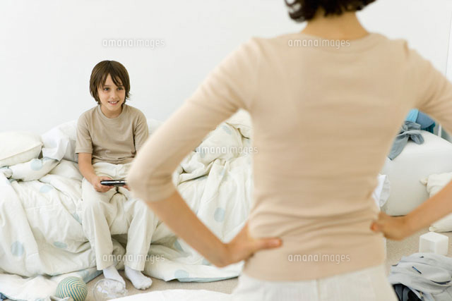 Boy playing handheld video game in messy bedroom
(c)Sigrid Olsson/PhotoAlto