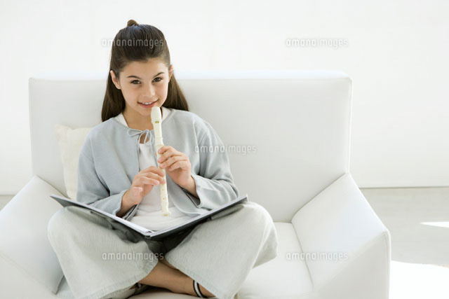 Girl sitting cross-legged on armchair,playing recorder
(c)Sigrid Olsson/PhotoAlto