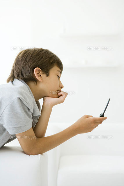 Boy looking at cell phone,hand under chin,side view
(c)Sigrid Olsson/PhotoAlto
