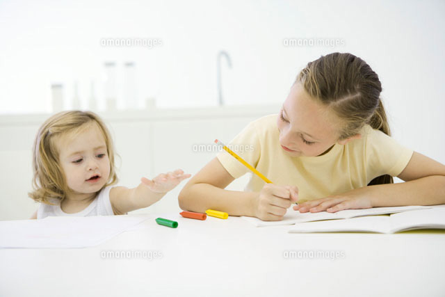 Girl doing homework at table,sister reaching for crayons
(c)Sigrid Olsson/PhotoAlto