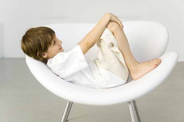 Boy reclining in chair,smiling,side view
(c)Sigrid Olsson/PhotoAlto