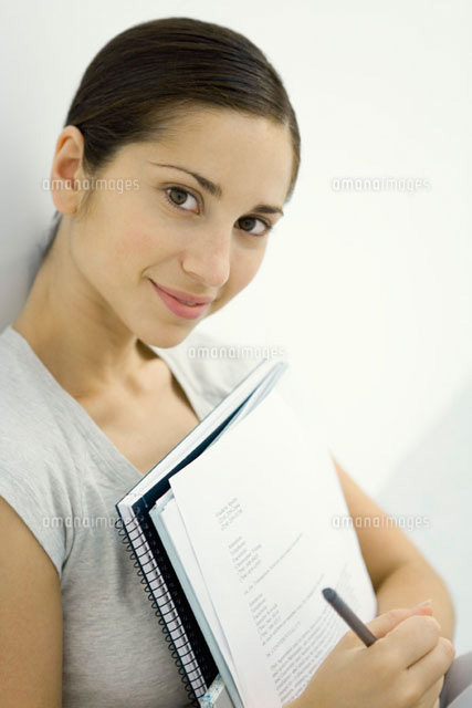 Woman holding documents and notebook,smiling at camera
(c)Sigrid Olsson/PhotoAlto
