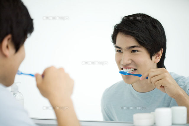 Young man brushing teeth,looking at self in mirror
(c)Ale Ventura/PhotoAlto