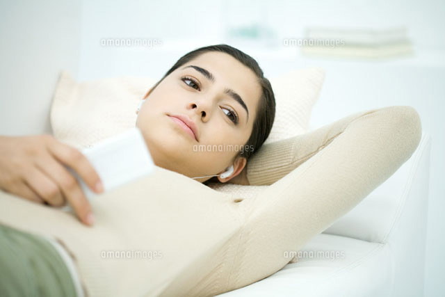 Young woman lying on back,listening to MP3 player
(c)Ale Ventura/PhotoAlto
