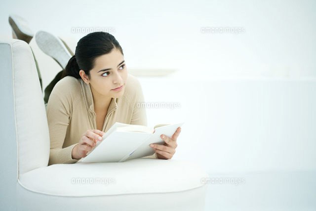 Young woman lying on stomach on sofa,holding book
(c)Ale Ventura/PhotoAlto