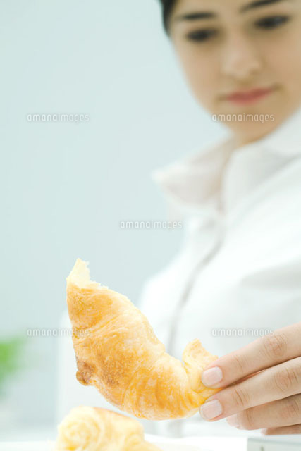 Young woman picking up croissant,low angle view
(c)Ale Ventura/PhotoAlto