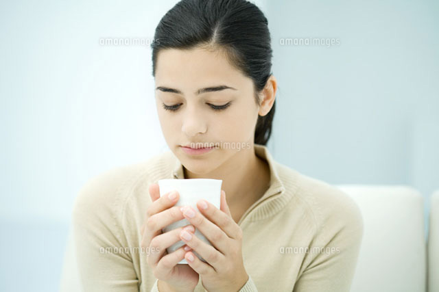 Young woman holding cup,looking down
(c)Ale Ventura/PhotoAlto
