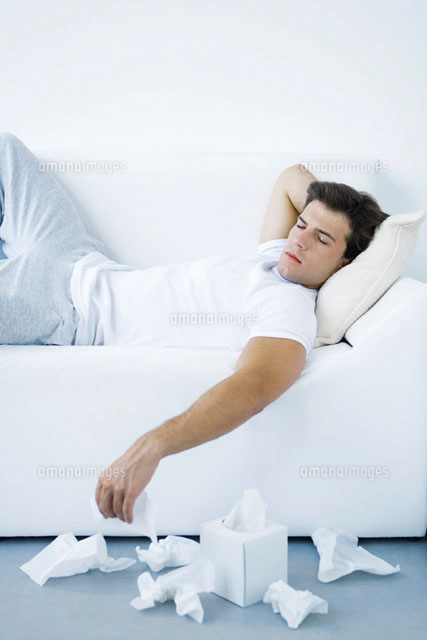 Man lying on sofa,discarded tissues on the floor
(c)Alix Minde/PhotoAlto
