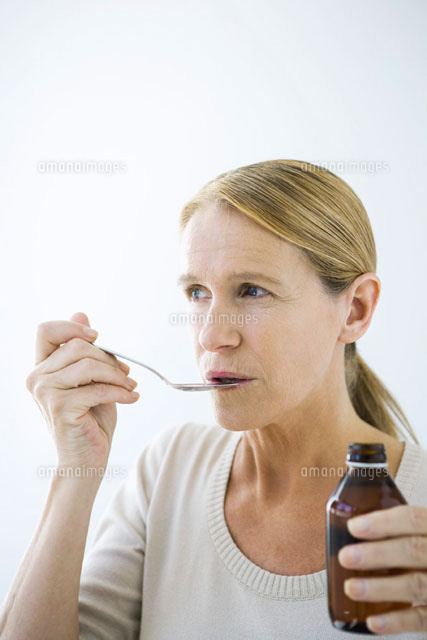 Mature woman taking a spoonful of medicine
(c)Alix Minde/PhotoAlto