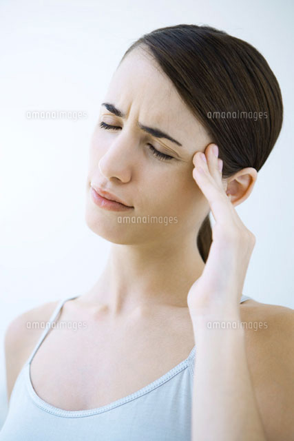 Woman massaging her temple and furrowing her brow
(c)Alix Minde/PhotoAlto