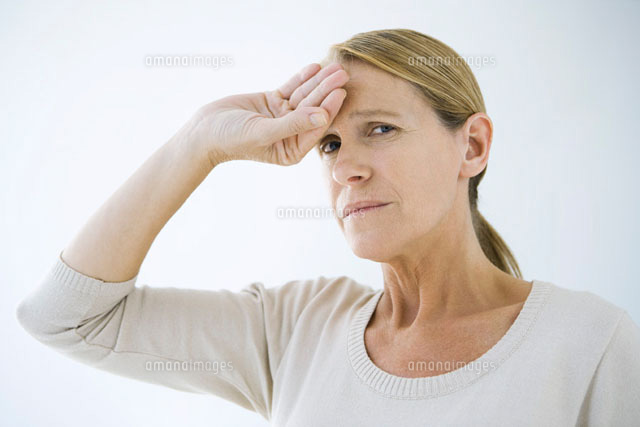 Woman holding hand on her forehead,frowning at camera
(c)Alix Minde/PhotoAlto