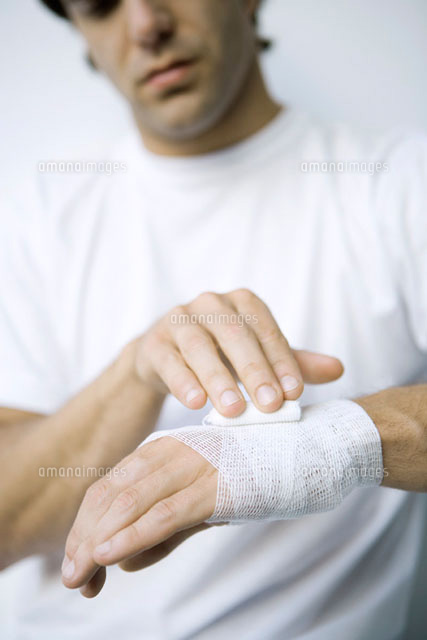 Man wrapping gauze around his wrist and hand,cropped view
(c)Alix Minde/PhotoAlto