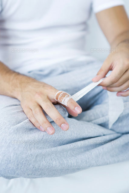 Man wrapping gauze around injured finger,cropped view
(c)Alix Minde/PhotoAlto