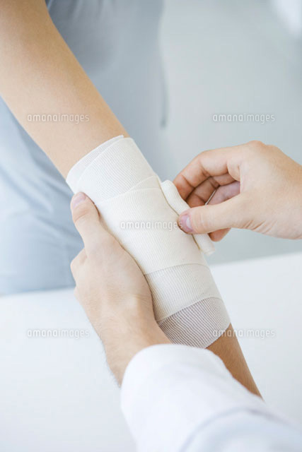 Doctor bandaging patient’s arm,cropped view
(c)Alix Minde/PhotoAlto