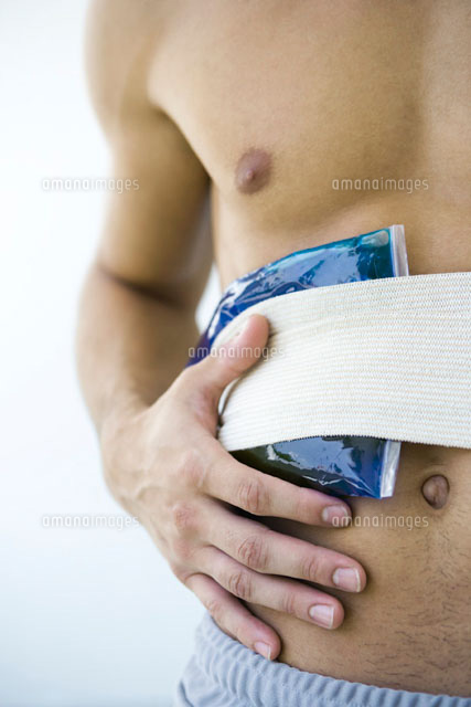 Man holding cold compress against abdomen,cropped view
(c)Alix Minde/PhotoAlto
