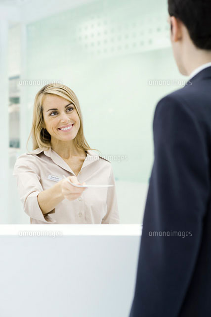 Woman standing behind counter,handing document
(c)Eric Audras/PhotoAlto