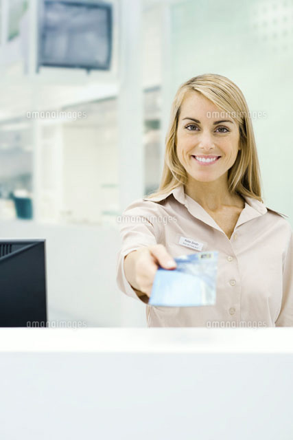 Travel agent holding out ticket,smiling at camera
(c)Eric Audras/PhotoAlto