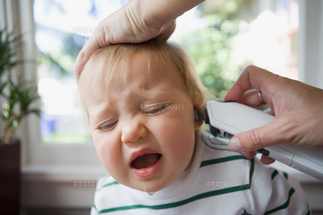 Adult putting thermometer in ear of crying baby
(c)Image Source
