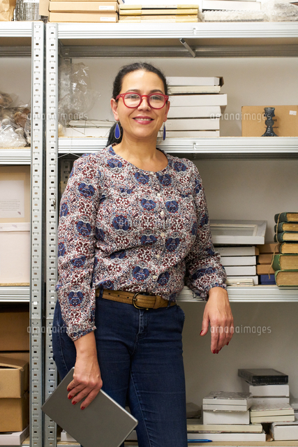 portrait of female small business owner in gift shop stockroom