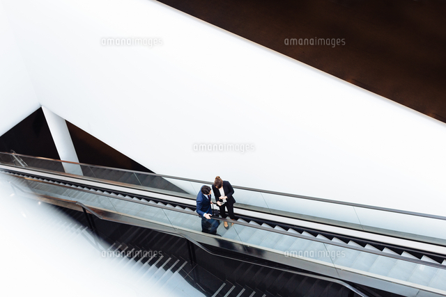 Businessman and businesswoman with wheeled luggage on escalator in hotel building
(c)Sofie Delauw/Cultura/Image Source RF