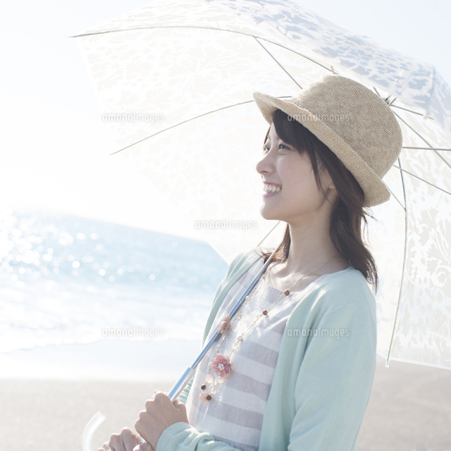 海で日傘をさし微笑む女性
(c)visual supple