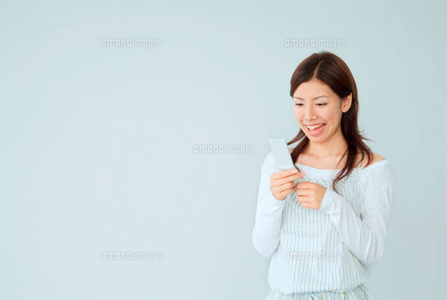 携帯メールをする20代日本人女性
(c)didi