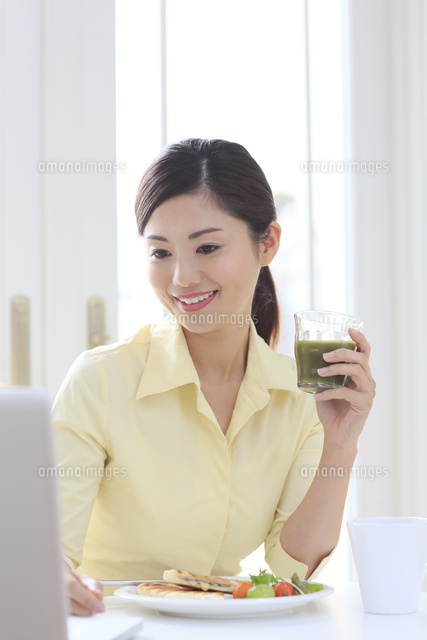 パソコンを見ながら朝食を食べる女性
(c)mon printemps
