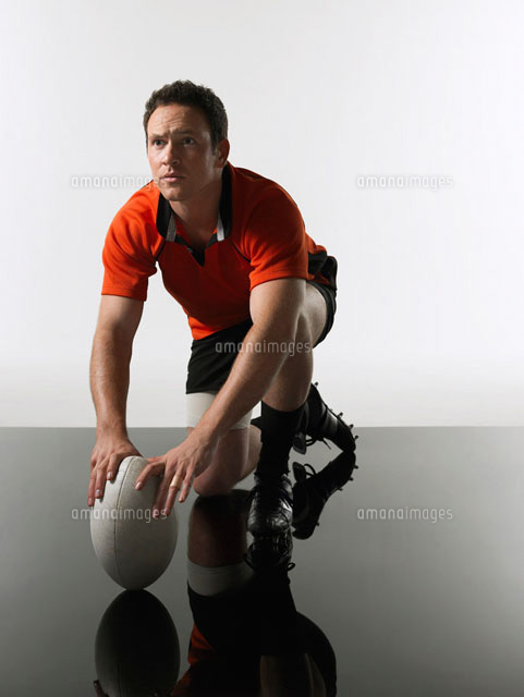 Rugby player kneeling on one knee holding ball
(c)moodboard