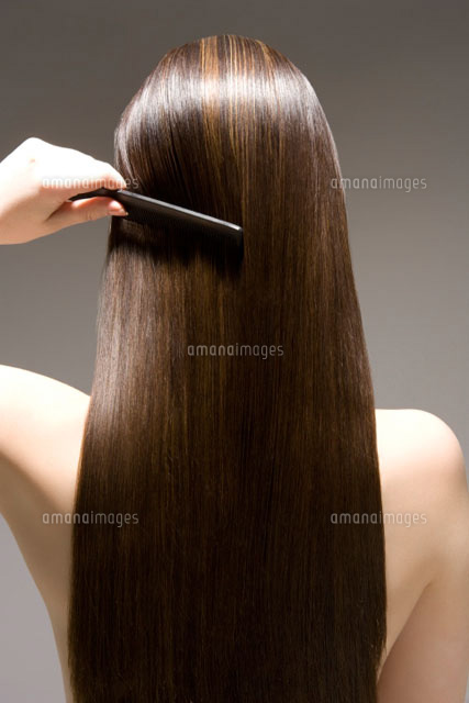 Woman combing long brown hair rear view
(c)moodboard