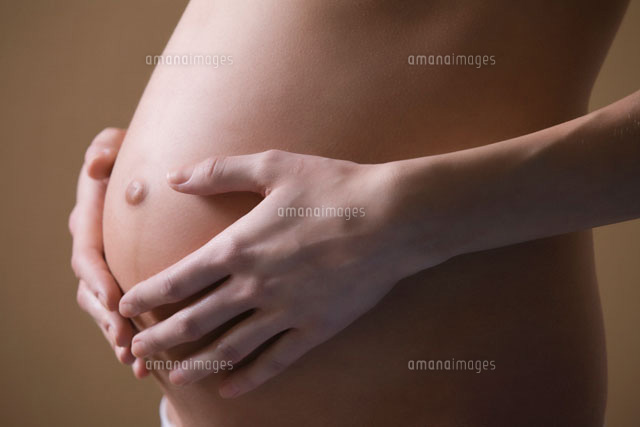 Pregnant woman stands with hands on stomach
(c)moodboard