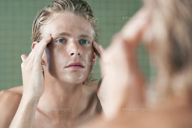 Man rubbing temples in front of mirror
(c)moodboard