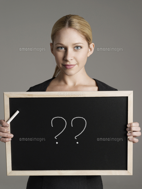 Portrait of young businesswoman holding blackboard with ques
(c)moodboard