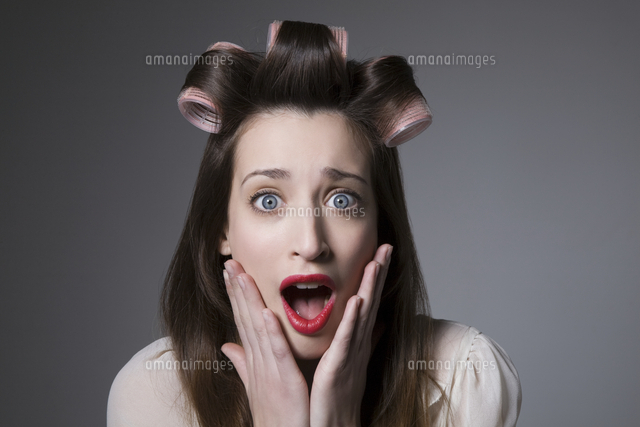 Surprised young woman with hair curlers and red lipstick
(c)moodboard
