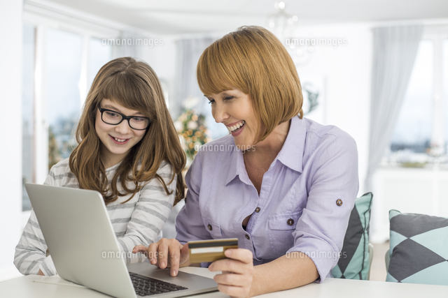 Cheerful mother and daughter shopping online at home during Christmas
(c)moodboard