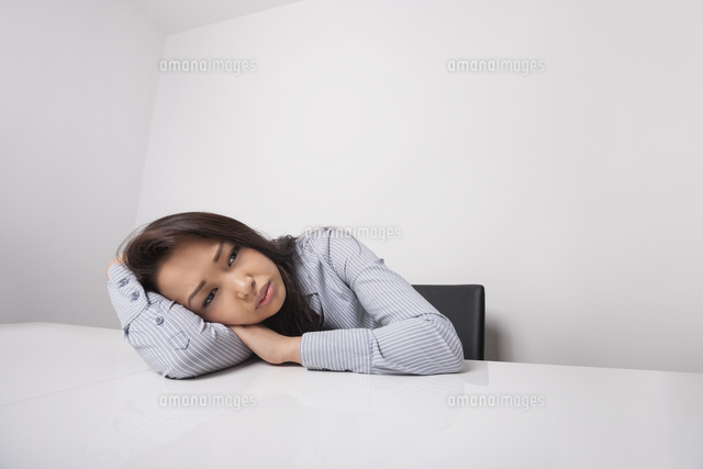 Tired businesswoman leaning at office desk
(c)moodboard