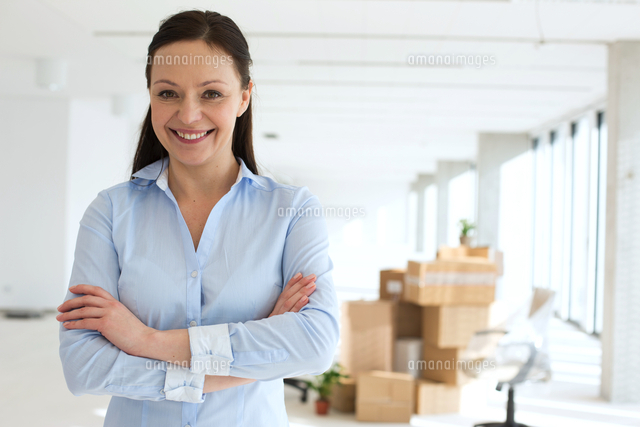 Portrait of smiling mid adult businesswoman standing arms crossed in new office
(c)moodboard