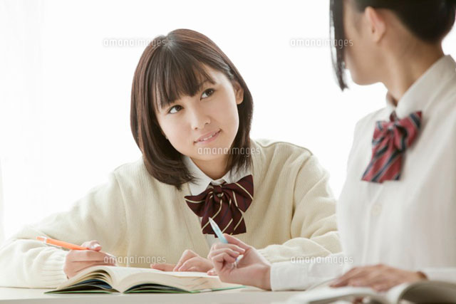 授業中に言葉を交わす女子高校生
(c)iconics
