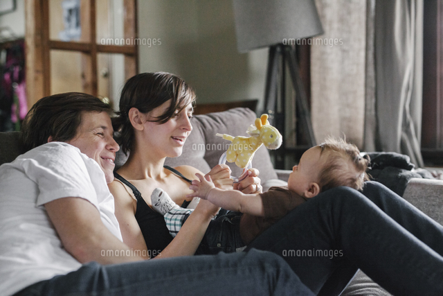 A same sex couple, two women looking at their 6 month old baby girl.
(c)Mint Images