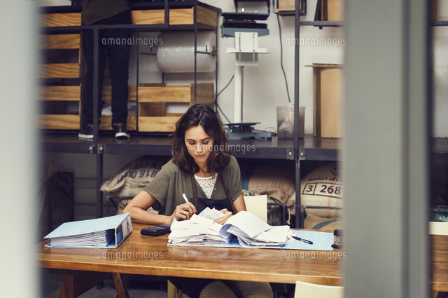 Mature female owner analyzing documents at table in coffee shop
(c)Cavan Images