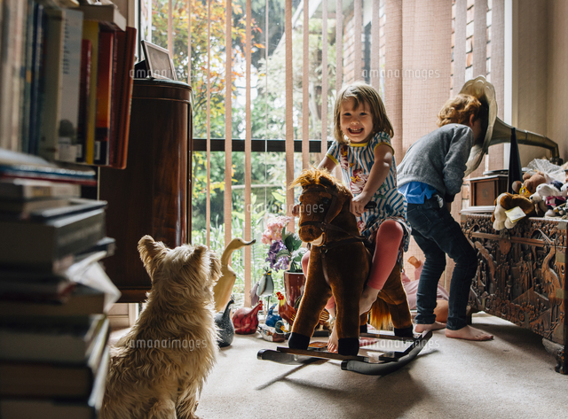 Happy siblings playing at home with dog sitting in foreground
(c)Cavan Images