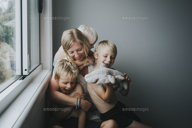Happy mother with children sitting by window at home
(c)Cavan Images