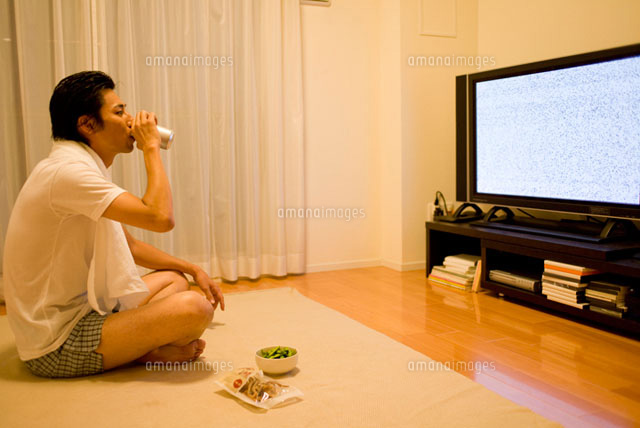 缶ビールを飲みながらテレビを見る男性
(c)DAJ