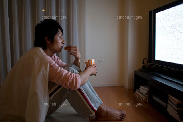 ポップコーンを食べながらテレビを見る男性
(c)DAJ