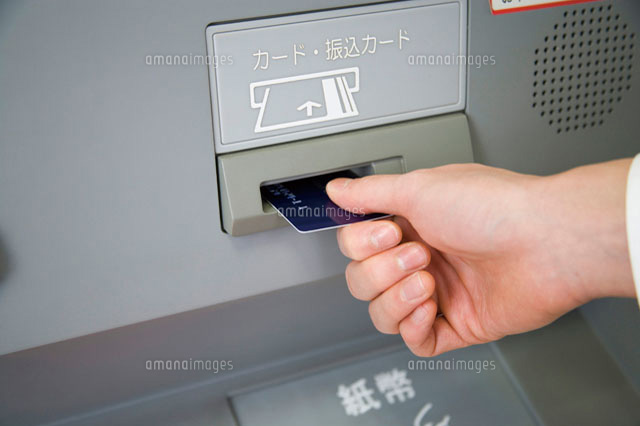 ATMにカードを入れる人
(c)daj