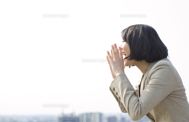 手を口にあてて大声を出すビジネス女性
(c)apjt